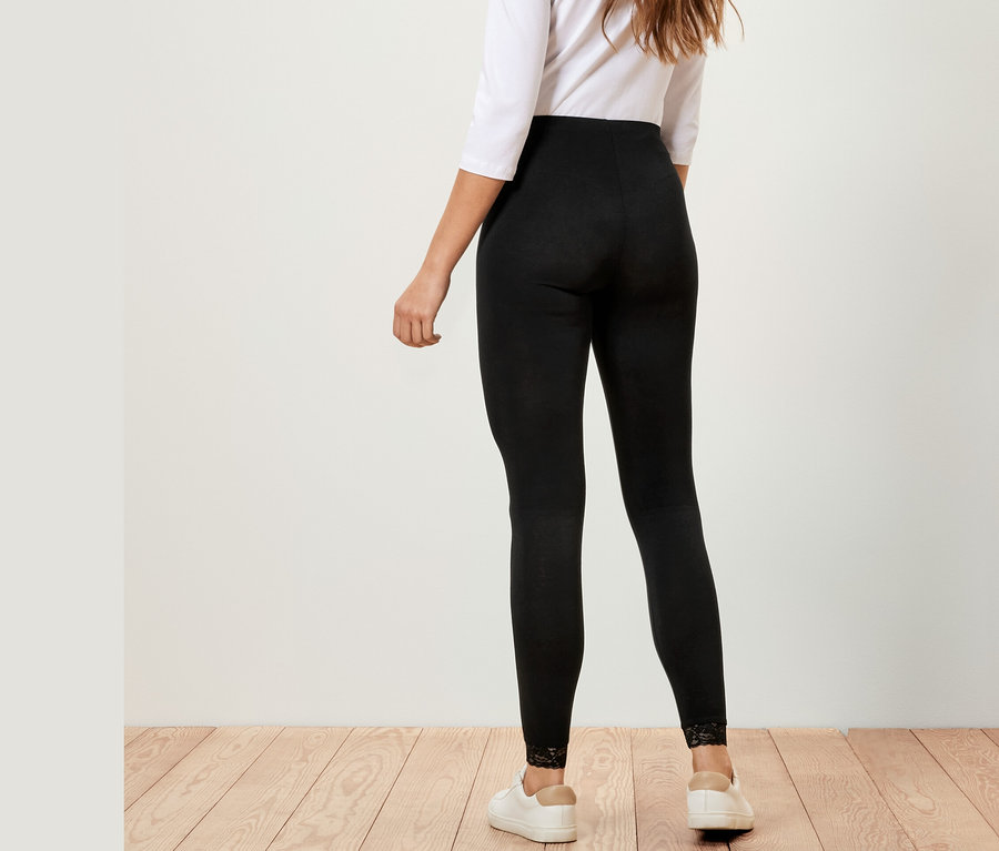 Une femme, vue de dos, porte un legging avec bordure en dentelle, un haut blanc et des baskets blanches.