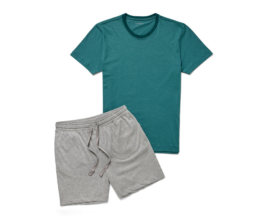 Un t-shirt vert et un short gris de l'ensemble pyjama shorty sont posés sur un fond blanc.
