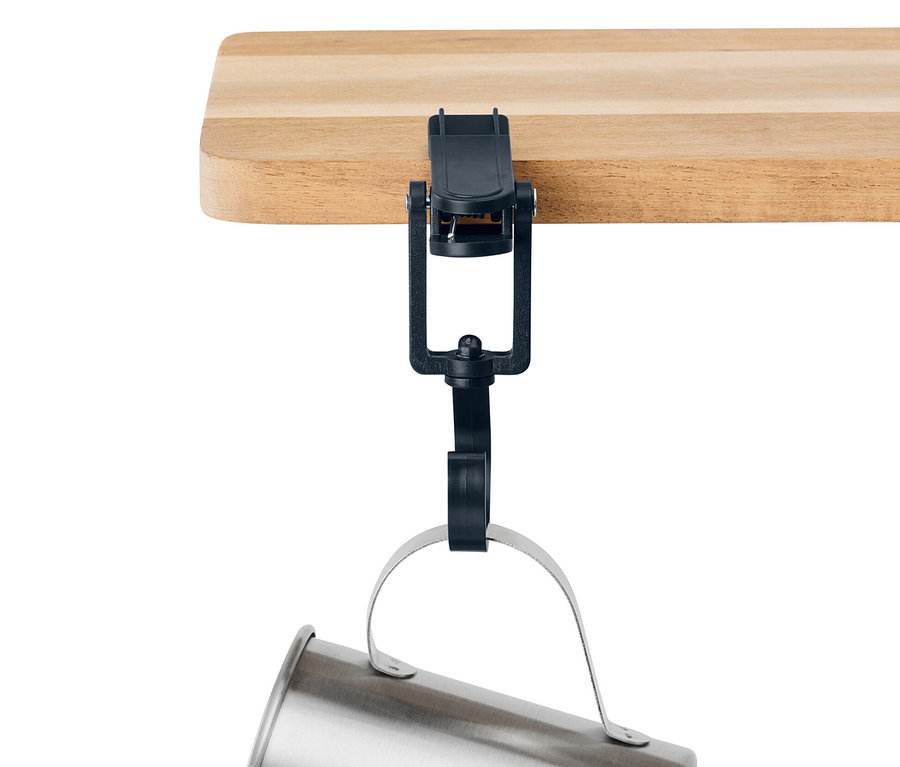 Une tasse argentée est suspendue au bord d'une étagère en bois à l'aide de 6 clips d’extérieur noirs.