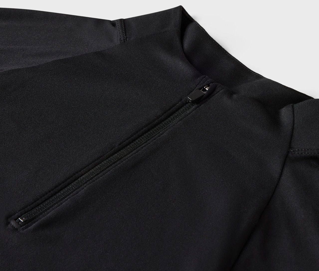 Gros plan sur un maillot de bain noir à manches longues avec fermeture éclair.