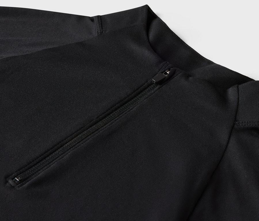 Gros plan sur un maillot de bain noir à manches longues avec fermeture éclair.