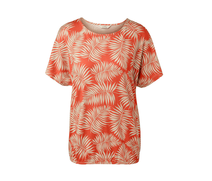 Une blouse imprimée avec un motif de feuilles sur un fond orange.