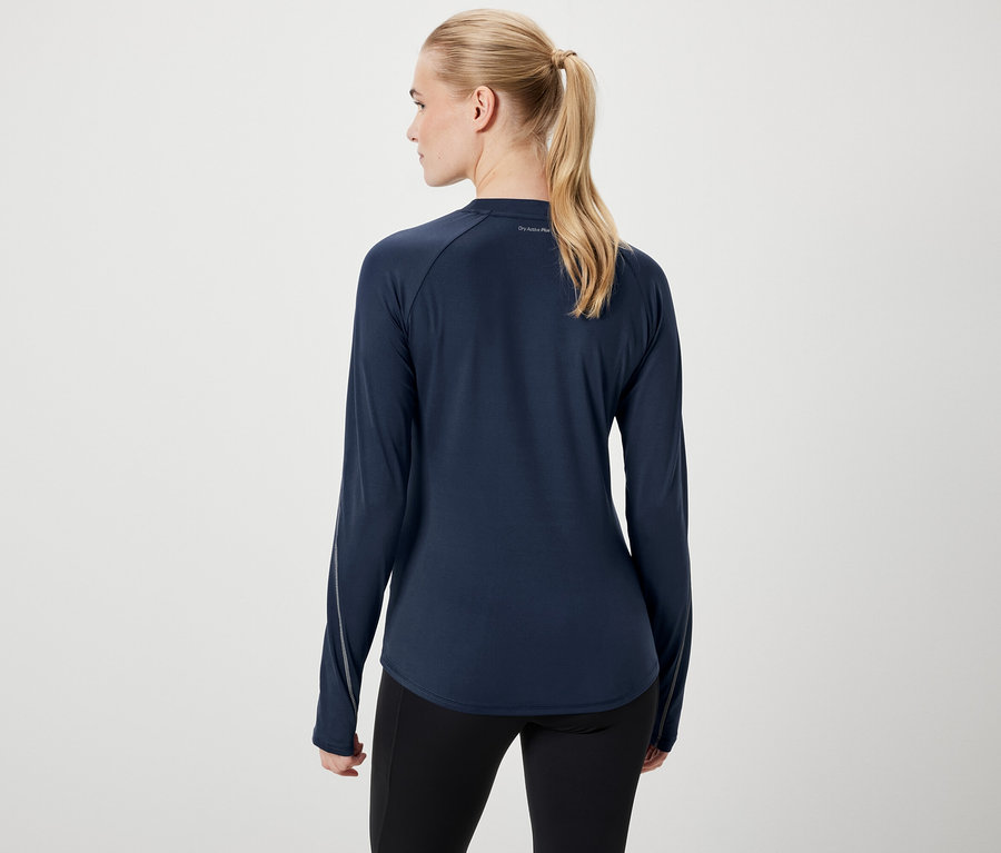 Vue arrière d'une femme aux cheveux blonds attachés en queue de cheval, portant un T-shirt à manches longues bleu foncé et un legging noir.