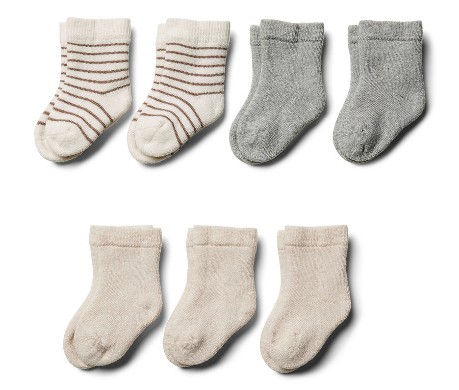 Sept paires de chaussettes en tissu éponge pour bébé de différentes couleurs et motifs.