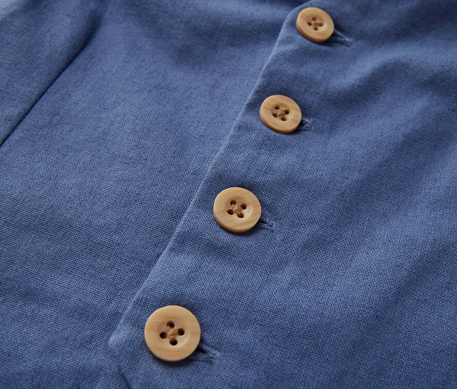 Détail d'un gilet pour enfant avec des boutons.