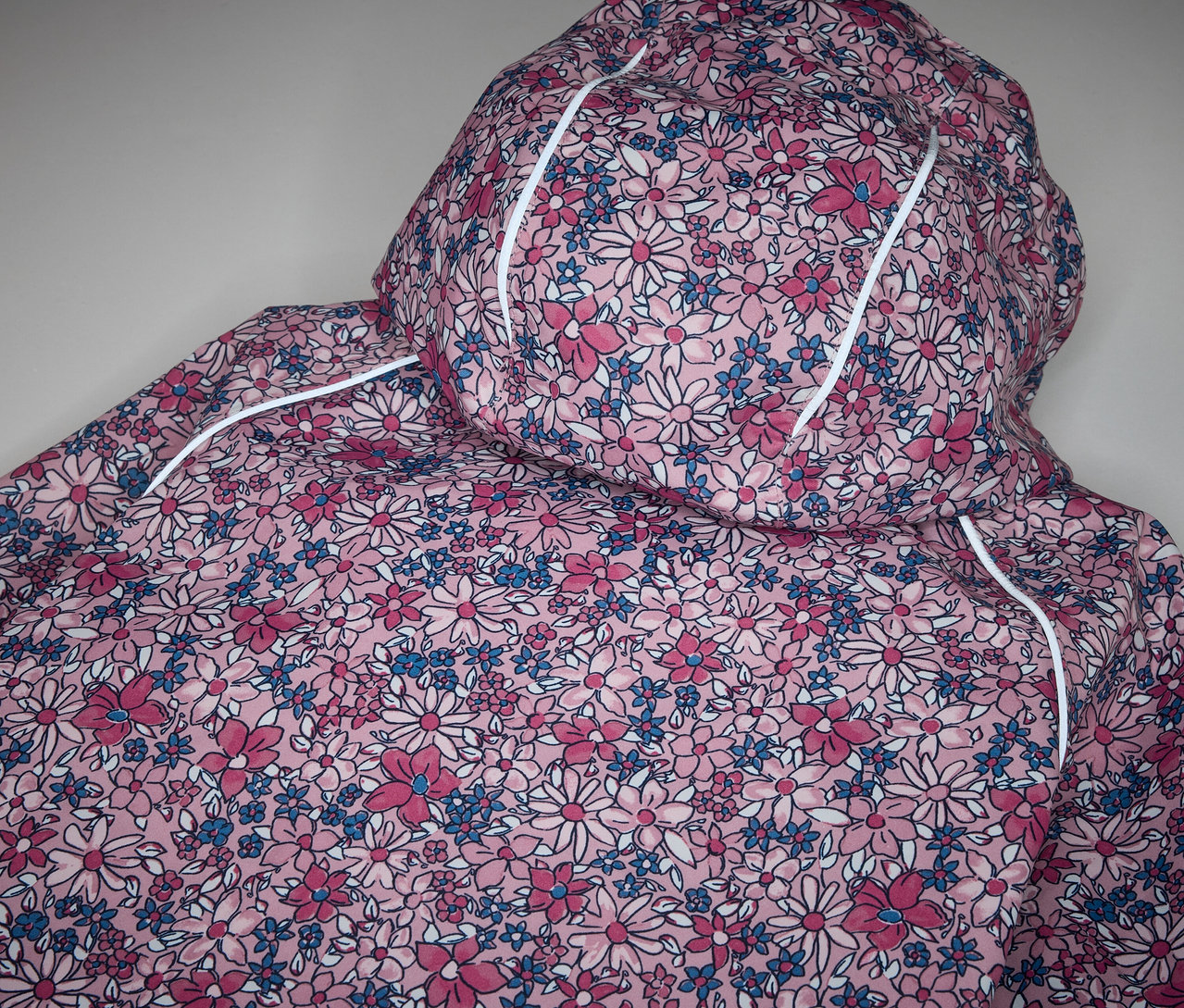 Détail d'une veste imperméable thermique pour enfants, à fleurs.