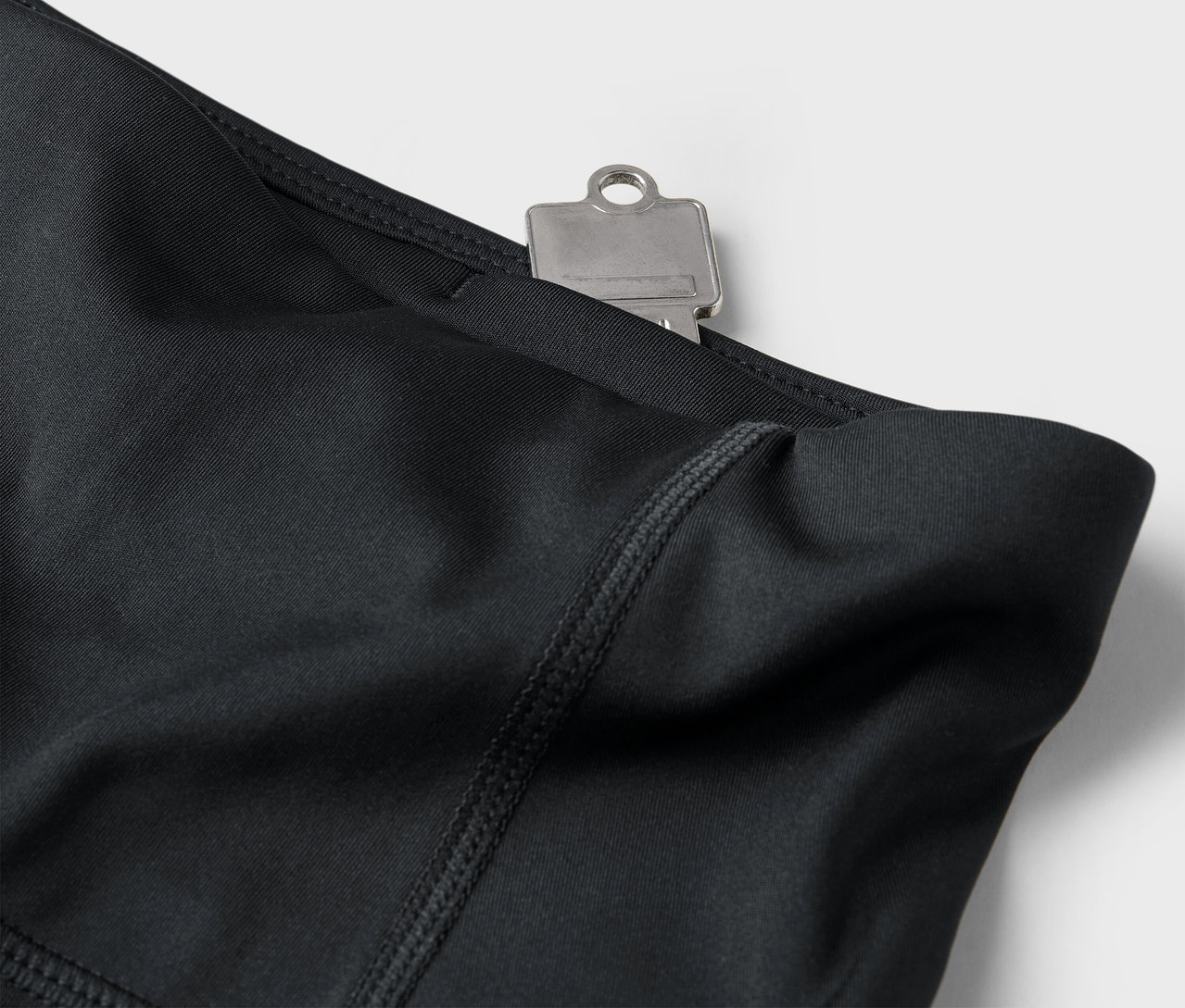 Gros plan sur un legging noir avec une clé dans la poche.