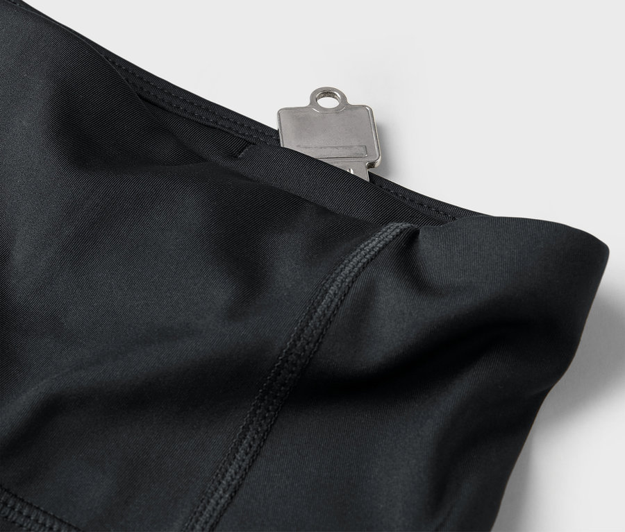 Gros plan sur un legging noir avec une clé dans la poche.