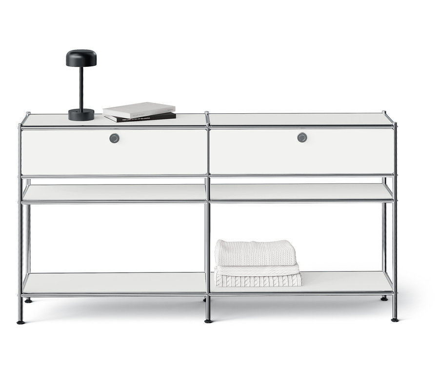 Système de rangement modulaire blanc avec deux tiroirs, des étagères ouvertes et une lampe sur le dessus.