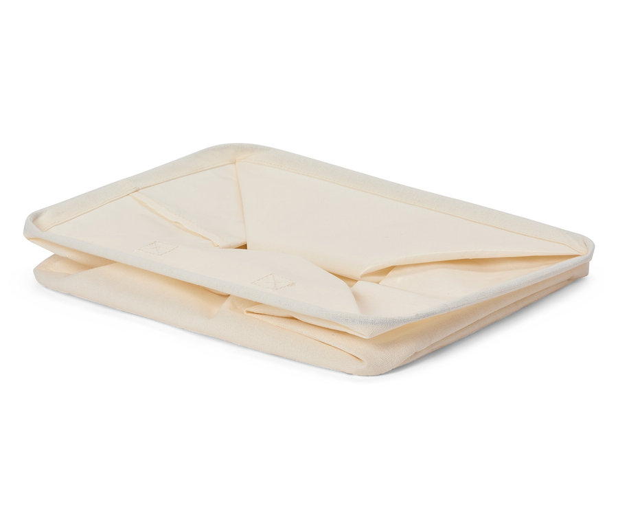 Boîte de rangement en tissu pliée de couleur crème.