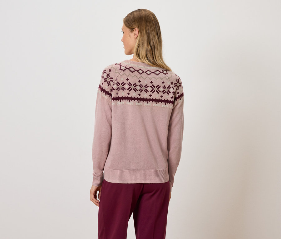 Femme vue de dos portant un pull rose à motif géométrique et un pantalon bordeaux.