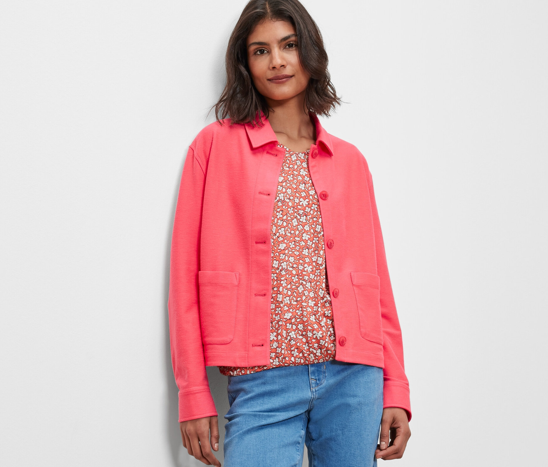 Femme portant une veste en jersey rose et un jean.