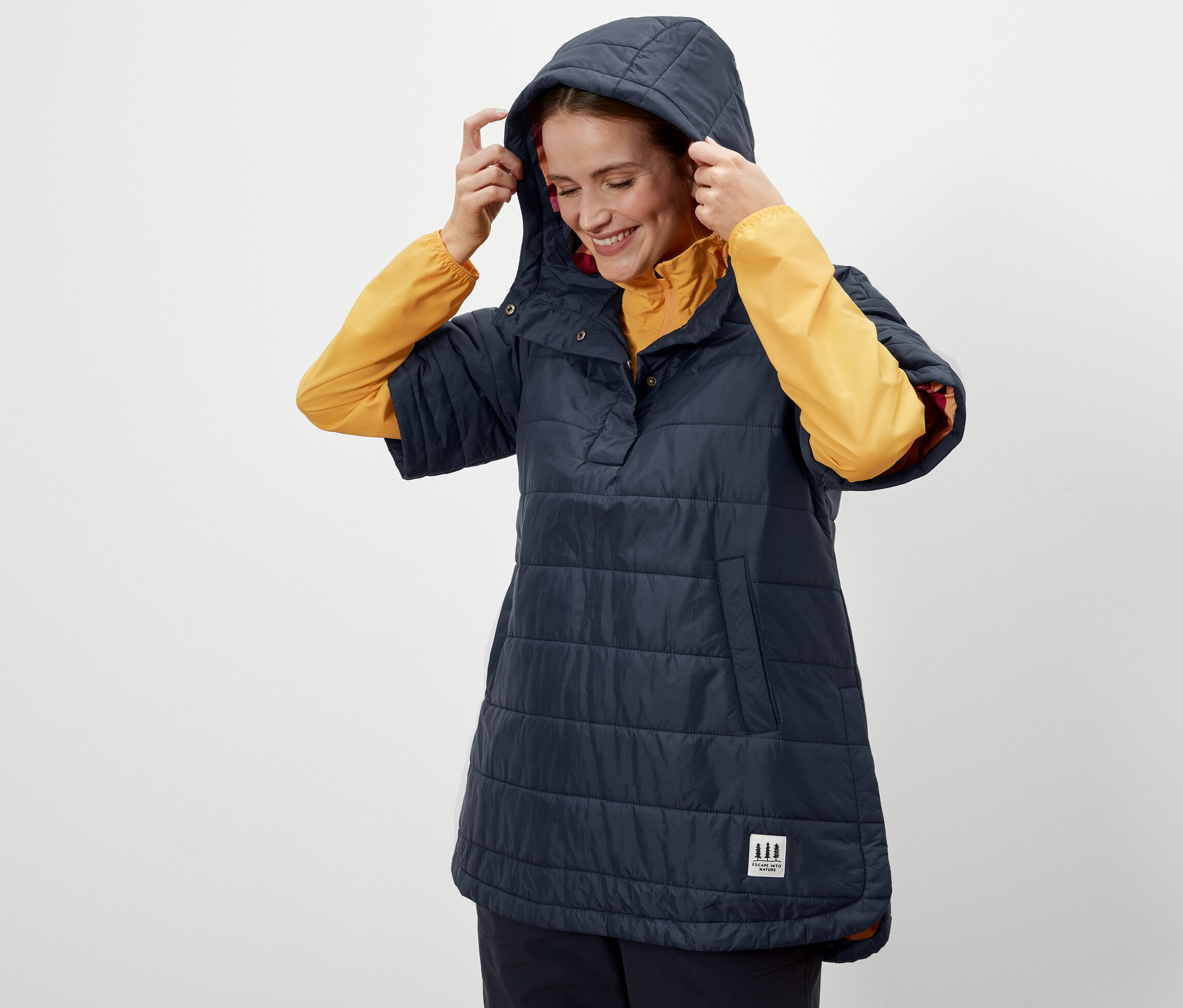 Femme ajustant la capuche d'un poncho d'extérieur.