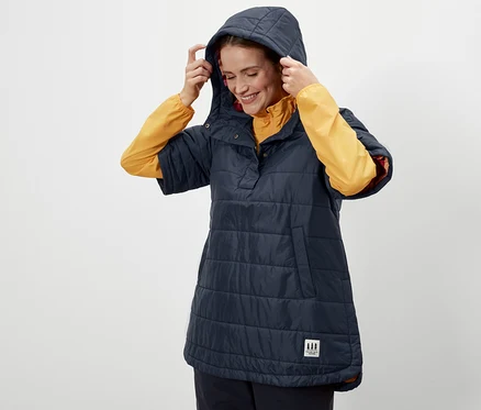 Femme ajustant la capuche d'un poncho d'extérieur.