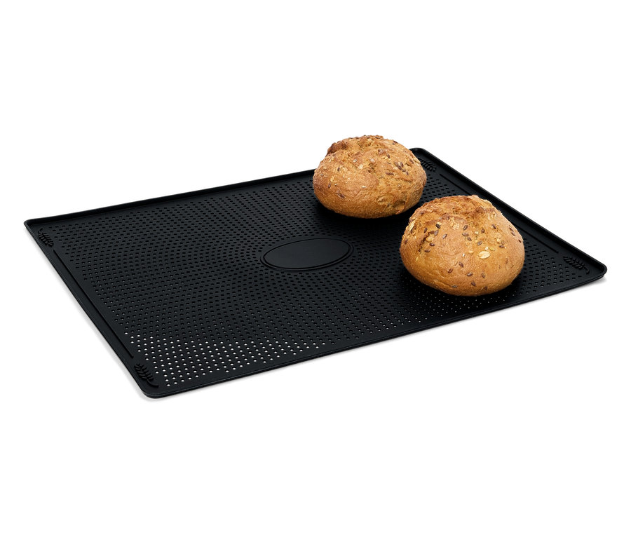 Deux pains reposent sur une plaque de cuisson noire perforée.