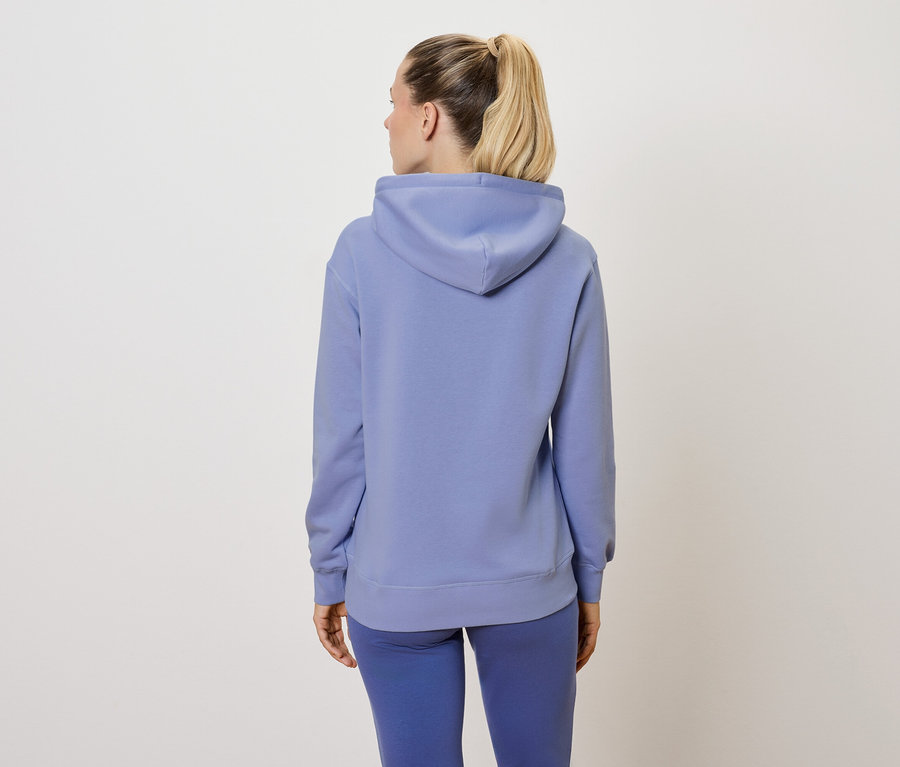Femme vue de dos portant un survêtement bleu.