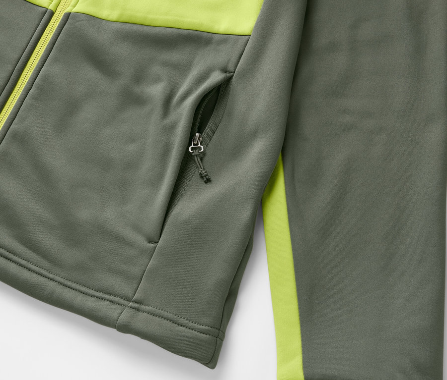 Détail d'une veste thermique grise avec des détails vert lime et une poche zippée.