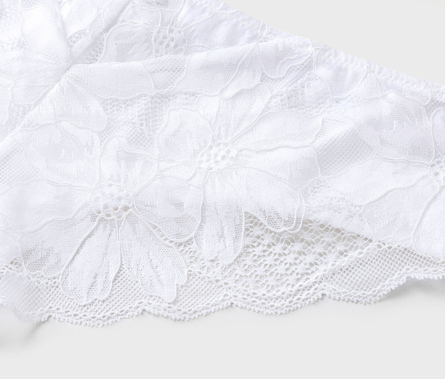 Gros plan de dentelle blanche avec motif floral.