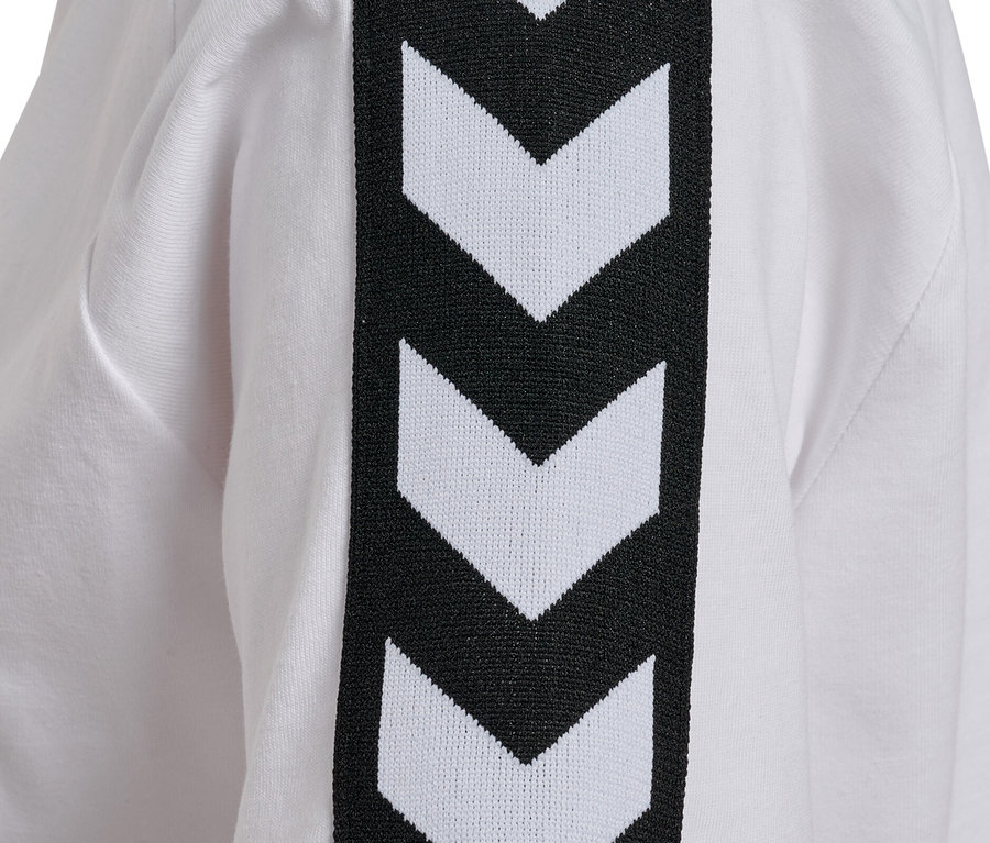 Gros plan sur un t-shirt hummel® pour femme blanc avec des chevrons noirs et blancs sur la manche.