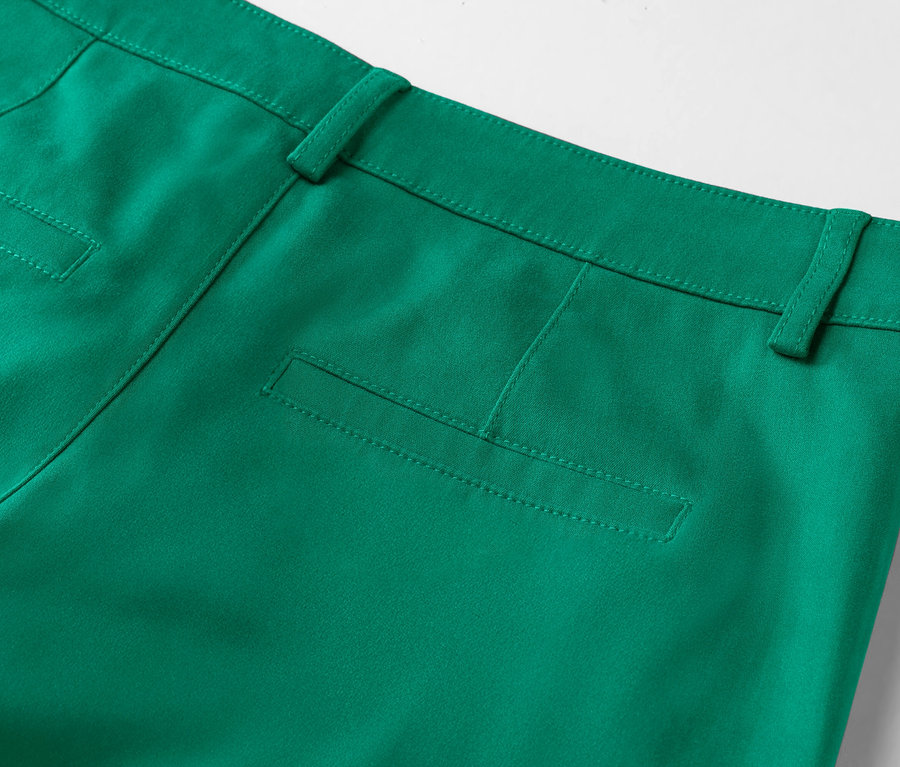 Gros plan sur l'arrière d'un pantalon vert émeraude avec une poche suggérée.