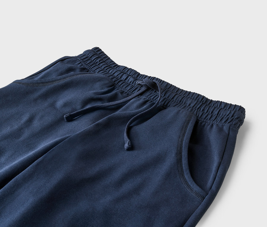 Gros plan sur un pantalon de jogging bleu marine avec cordon de serrage et poches.