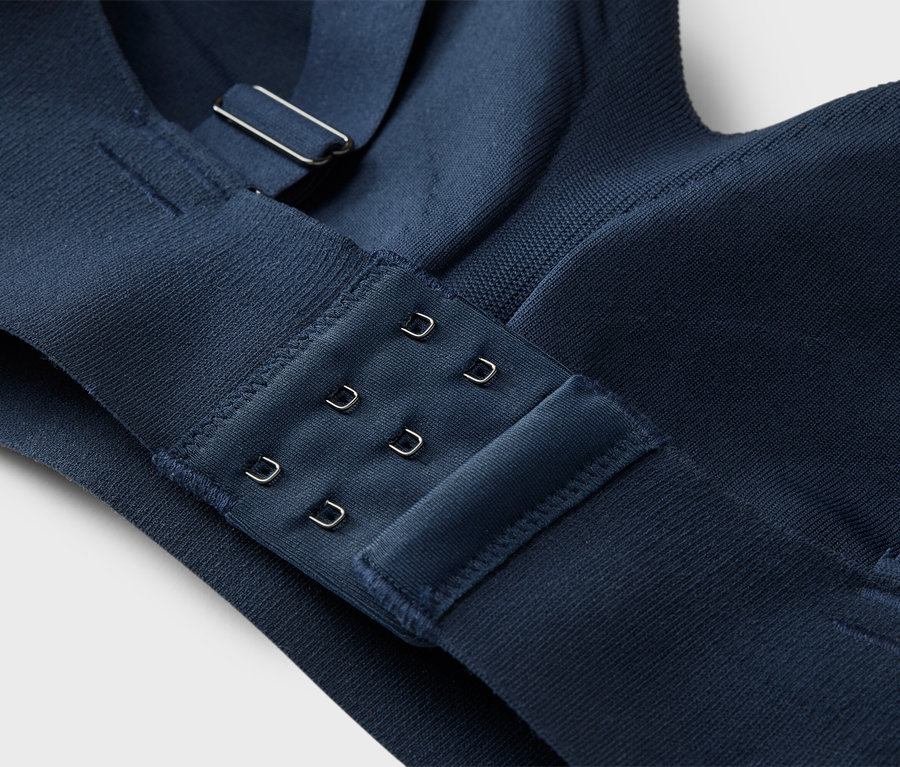 Gros plan sur une fermeture de soutien-gorge bleu marine à trois agrafes.