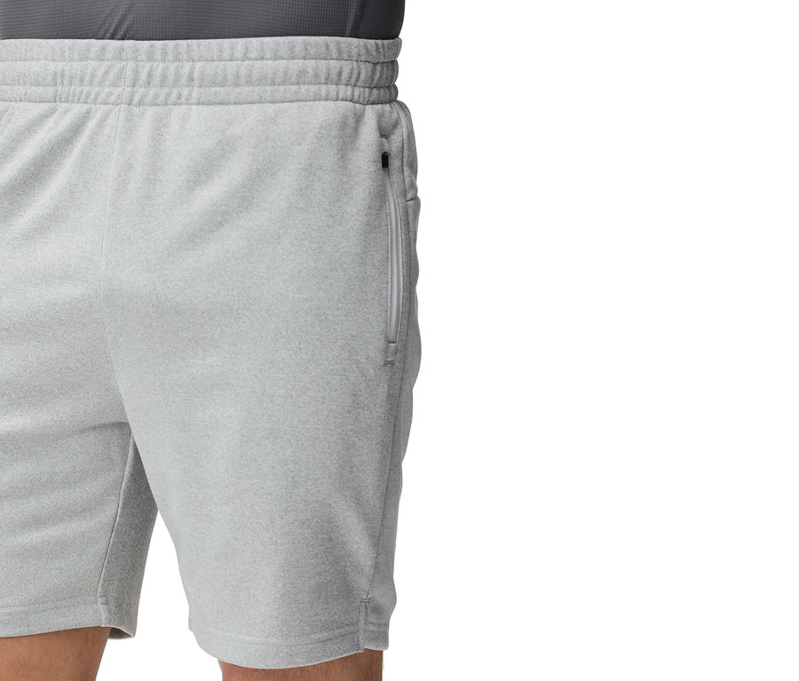 Gros plan d'un short d'entraînement gris clair avec une fermeture éclair sur la poche.