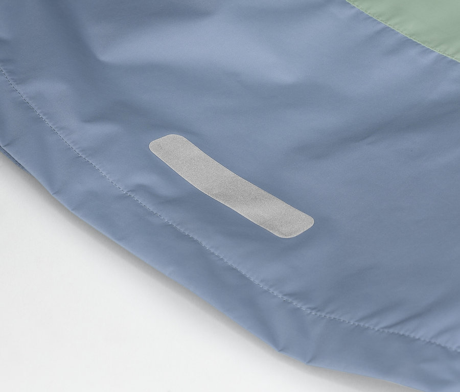 Gros plan d'une veste bleu-vert avec une bande réfléchissante sur le côté.