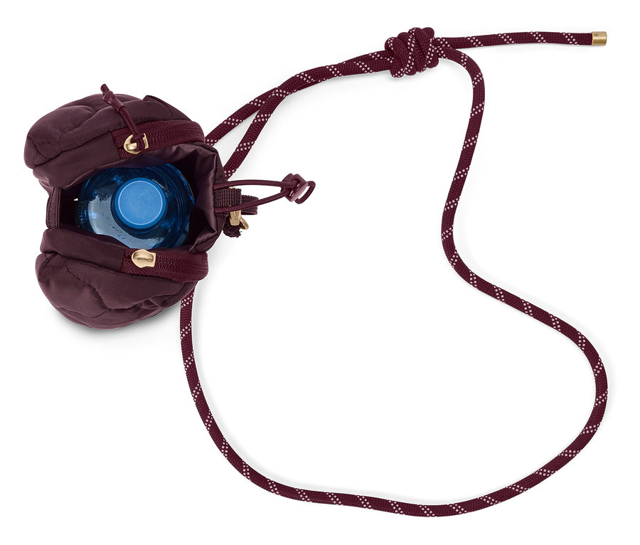 Une poche à eau matelassée aubergine avec une bouteille d'eau bleue à l'intérieur et un cordon bordeaux.