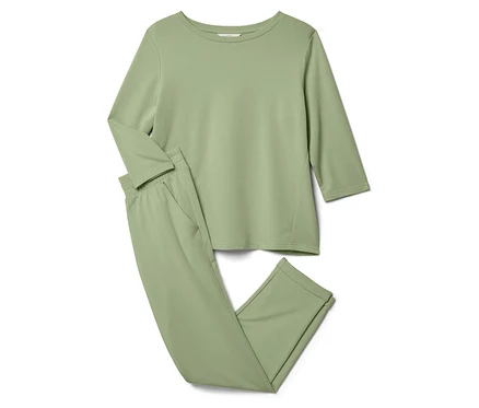 Un pyjama vert clair composé d'un haut à manches longues et d'un pantalon est posé sur un fond blanc.