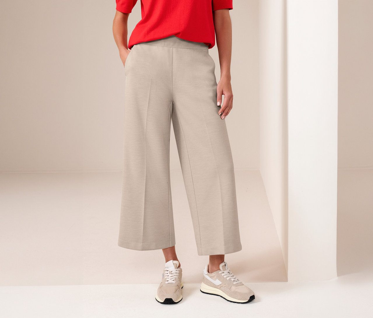 Femme portant un t-shirt rouge et une culotte 7/8 Street One beige avec des baskets.