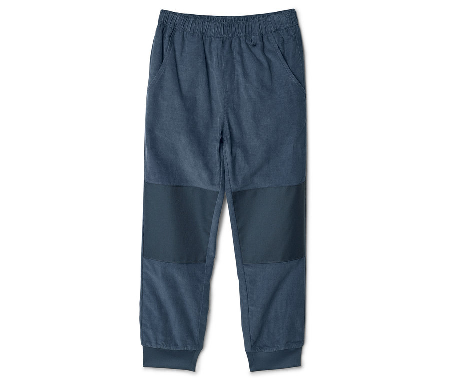 Un pantalon en velours côtelé bleu avec une taille élastique et des pièces aux genoux est posé sur un fond blanc.
