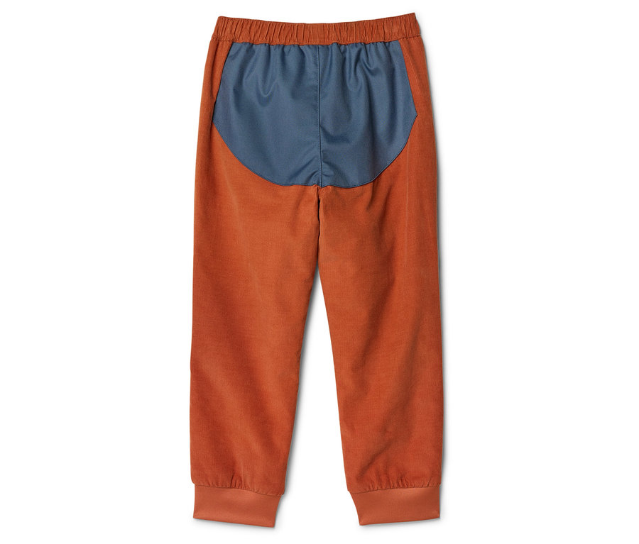Pantalon en velours côtelé orange avec taille élastique et empiècement bleu marine en haut du dos.