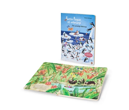 Le livre « Gustav le pingouin part en voyage » est debout, montrant sa couverture bleu clair avec des pingouins sur la glace. Une page ouverte est à plat, affichant une illustration de jungle avec des singes et des paresseux.