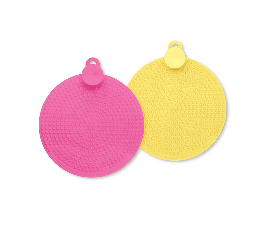 Gros plan d'un tapis en silicone rond rose et jaune avec des picots et un trou de suspension.