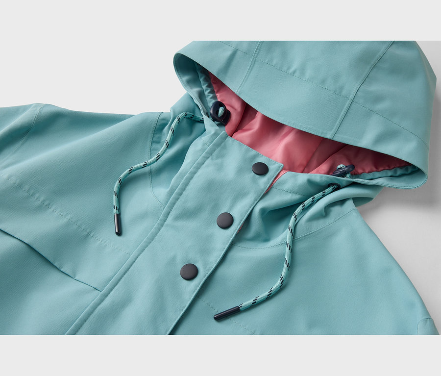 Gros plan d'une veste turquoise avec une doublure rose. La veste présente une capuche avec un cordon de serrage, une patte de boutonnage avec trois boutons noirs et un cordon de serrage rayé turquoise et noir au col.