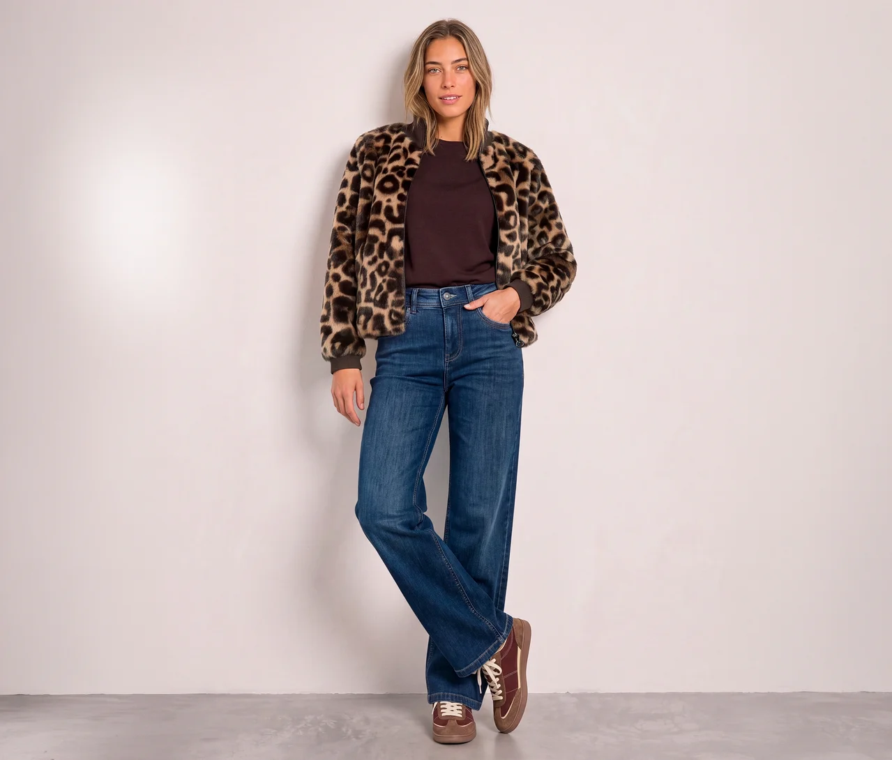 Une femme porte un Blouson Street One à imprimé léopard, un haut marron, un jean large et des chaussures lacées marron.