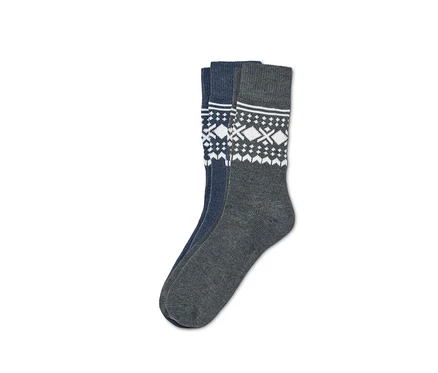 Deux paires de chaussettes jacquard. Une paire est bleue avec un motif blanc, l'autre grise avec un motif blanc.