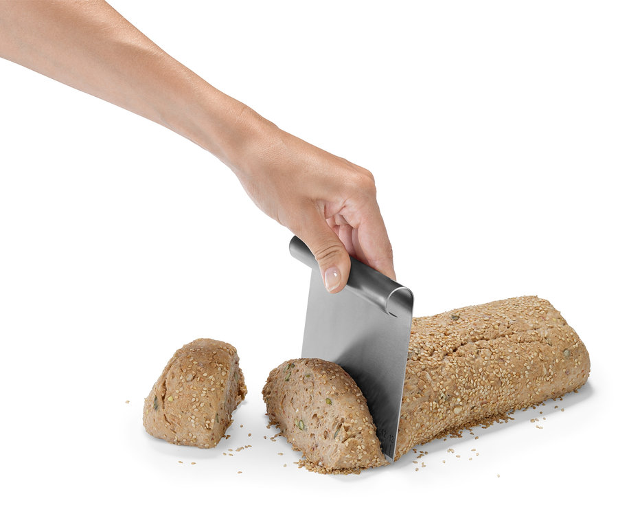 Une main coupe du pain avec un kit d'accessoires professionnels de pâtisserie.