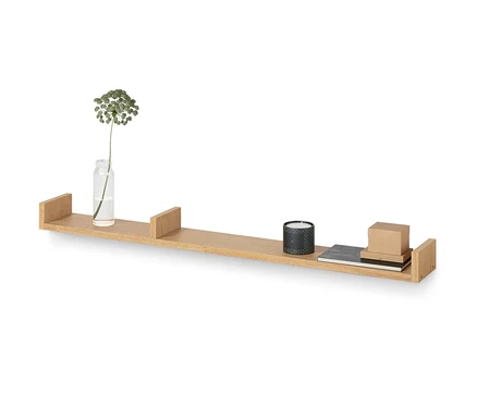 Une étagère murale en bois d'environ 120 cm est fixée au mur, sur laquelle reposent un vase avec une fleur, une bougie, un carnet et une boîte.