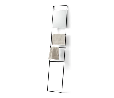 Échelle à serviettes noire avec miroir et deux serviettes beige.
