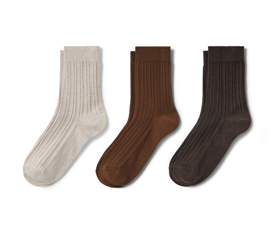 Trois paires de chaussettes à torsades en beige, marron et marron foncé.