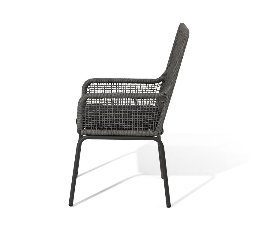 Vue latérale d'une chaise à dossier haut en textile tressé.