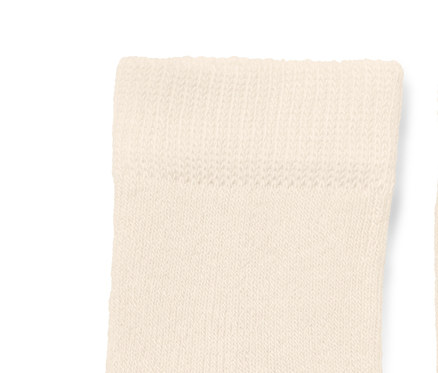 Deux chaussettes de bébé crème avec motif de baleine bleue.