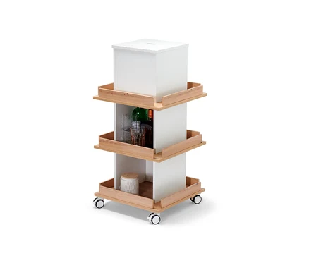 Tour de rangement blanche avec trois étagères et roulettes, sur lesquelles sont posés des verres, des bouteilles et une boîte.
