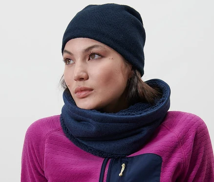 Une femme porte un bonnet en maille bleu.