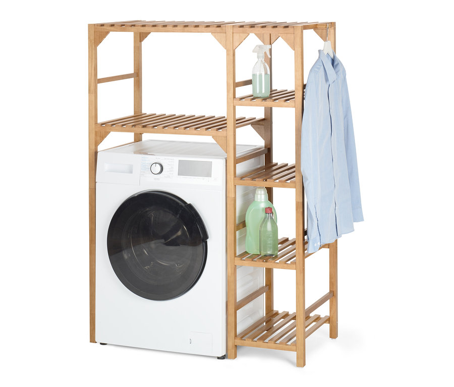Une machine à laver se trouve à côté d'une étagère à machine à laver avec un élément latéral. Des produits de lessive sont posés sur l'étagère et une chemise y est accrochée.