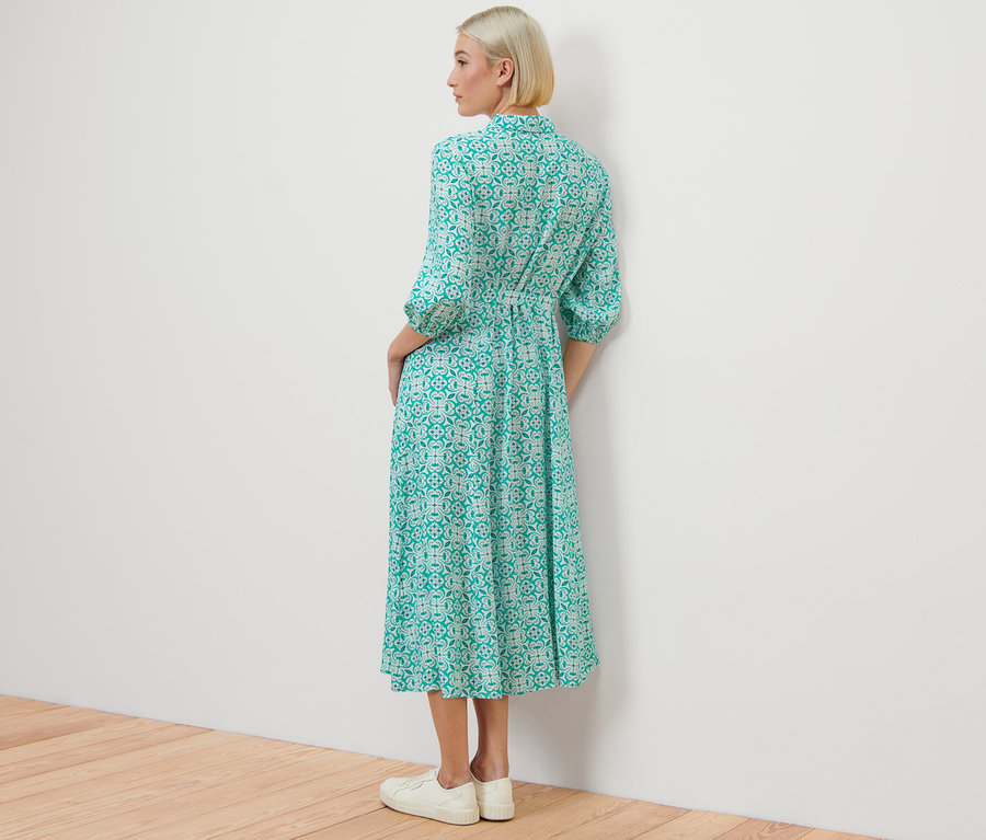 Une femme, vue de dos, porte une robe chemisier avec imprimé intégral.