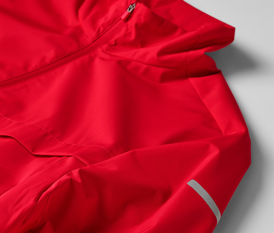Détail d'une veste technique coupe-vent rouge.