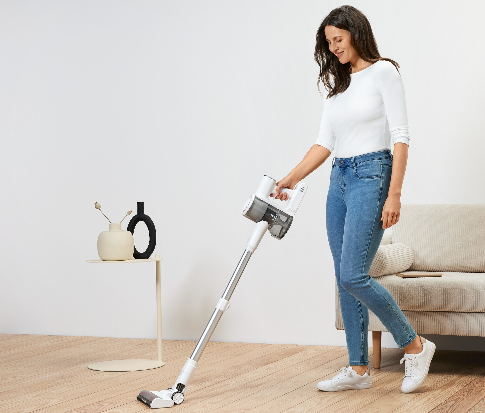 Femme utilisant un aspirateur sur batterie professionnel.